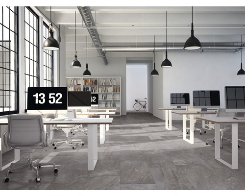 Lichte kantoorruimte met computers, bureaus, stoelen en een boekenkast op de achtergrond