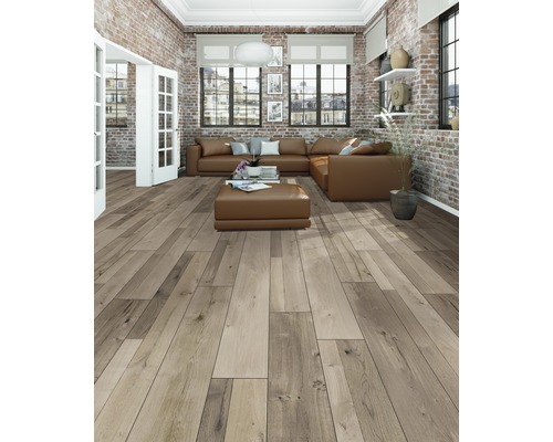 Lichte woonkamer met houten vloer, leren bank en bakstenen muur