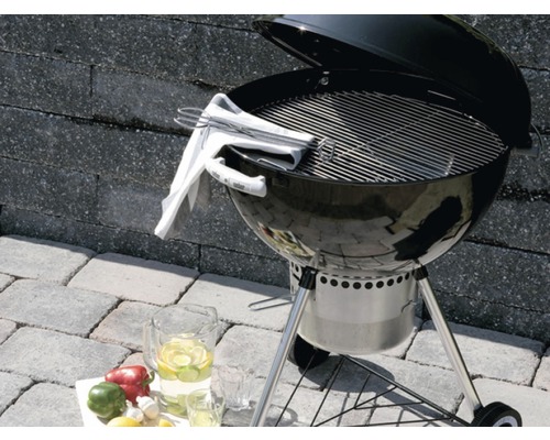 Bolvormige barbecue met grillrooster en accessoires op een terras