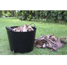 Eimer met herfstbladeren in de tuin.