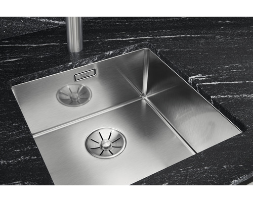 Roestvrijstalen gootsteen met afvoersysteem en zwart werkblad