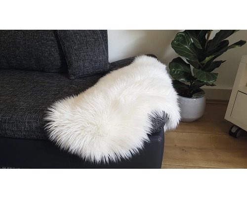 Witte schapenvacht op een grijze bank