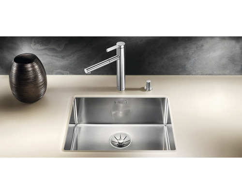 Roestvrijstalen spoelbak met kraan en zeepdispenser op een werkblad