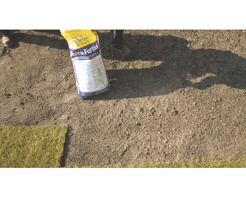 Bodemverbeteraar wordt aangebracht op een voorbereide ondergrond voor graszoden.