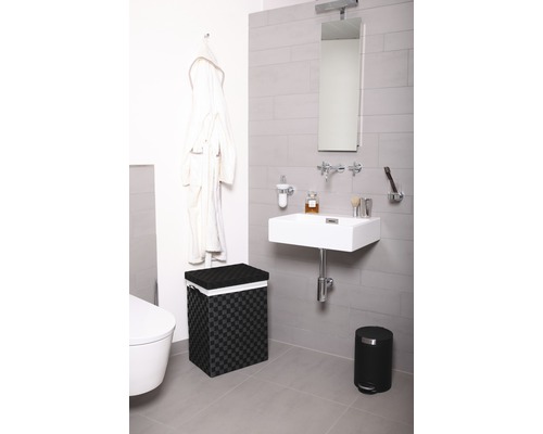 Moderne badkamer met wastafel, spiegel, wasmand en afvalemmer.