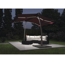 Tuinscene met een zweefparasol met ledverlichting boven een loungeset
