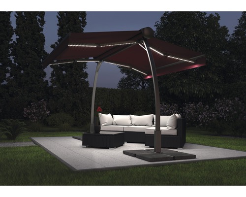 Tuinscene met een zweefparasol met ledverlichting boven een loungeset