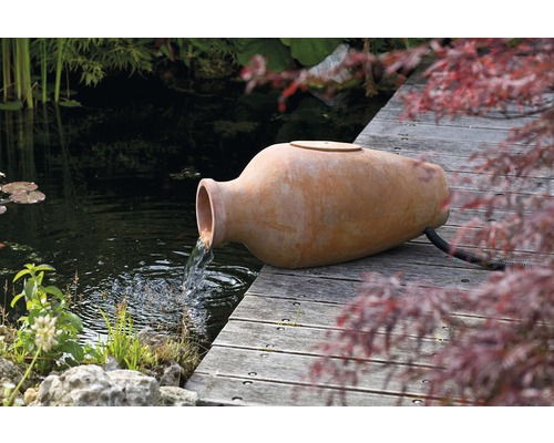 Terracotta kruik als waterspuwer voor de tuinvijver op houten steiger