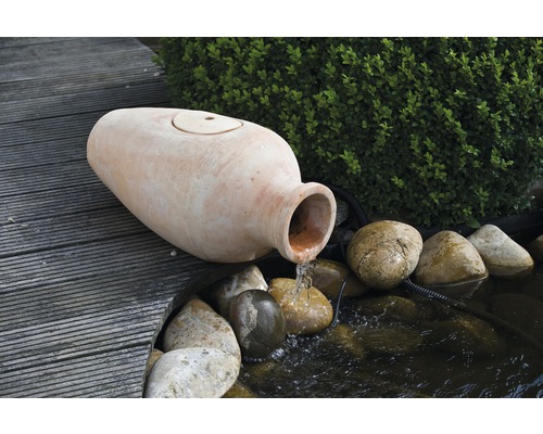 Tuin fontein met terracotta amfora en waterloop in een vijver met stenen