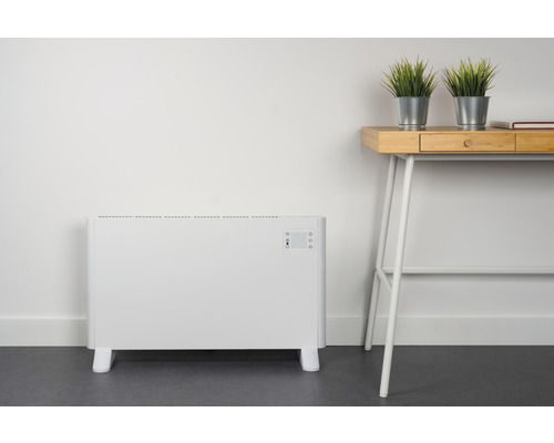 Elektrische convectorverwarming naast een bureau