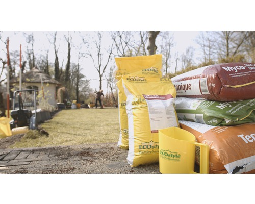Tuinlandschap met zakken potgrond en maatbeker