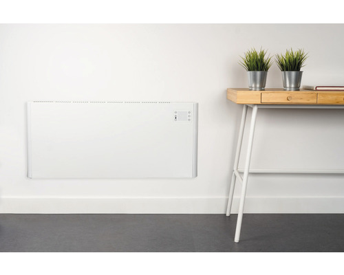 Wandconvectorverwarming in een kamer met bureau en decoratie