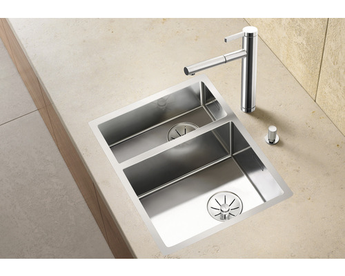 Roestvrijstalen spoelbak met twee bakken en kraan op een aanrecht