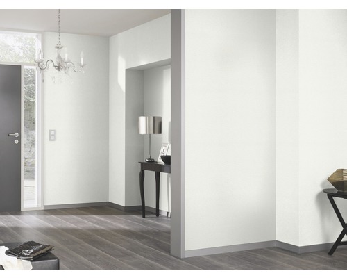 Lichte kamer met deur, kroonluchter en houten vloer.