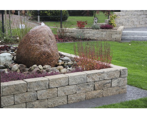 Tuin met natuurstenen muur, fontein en beplanting