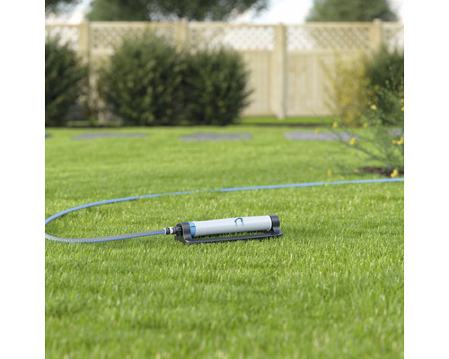 Tuinsproeier met slang op gazon