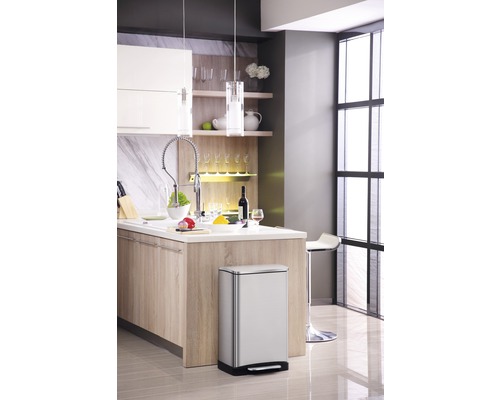 Moderne keuken met roestvrijstalen pedaalemmer, kookeiland en verlichting