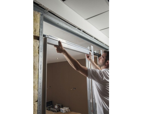 Man monteert een gipsplaatwand met metalen profielen in een kamer.