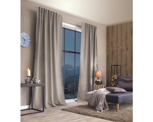 Woonkamer met gordijnen, bank, tafel en decoratie