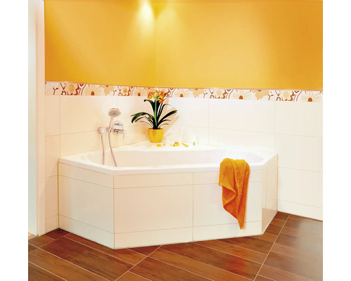 Hoekbad met kraan, handdoek en decoratieve plant in een lichte badkamer