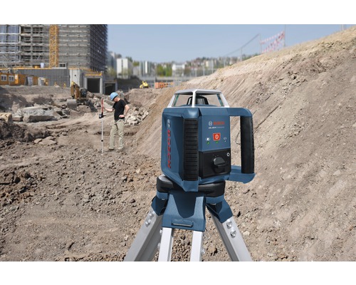 Bouwplaats scène met een Bosch roterende laser op een statief voor horizontale nivellering