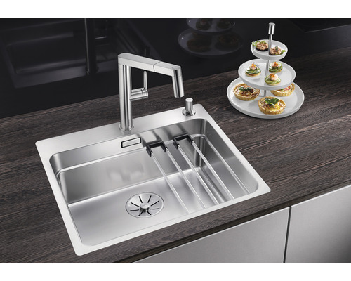 Roestvrijstalen spoelbak met afdruiprek en kraan op een aanrecht.