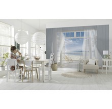 Lichte woonkamer met eettafel, stoelen en een muurschildering met strandthema