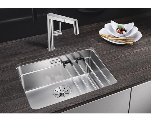 Roestvrijstalen spoelbak met afdruiprek en keukenkraan op een werkblad