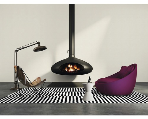 Woonkamer met hangende open haard, fauteuil en staande lamp op een zwart-wit gestreept vloerkleed