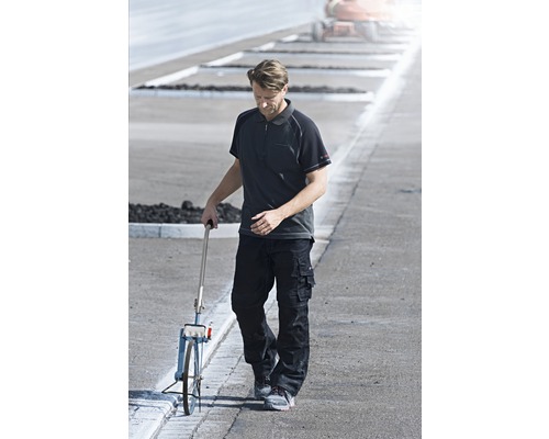 Man met meetwiel op straat in werkkleding