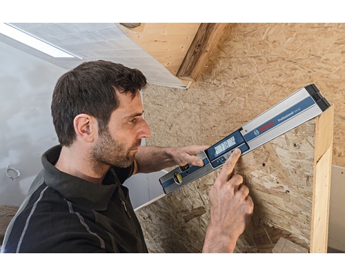 Man gebruikt digitale waterpas van Bosch om hout te meten