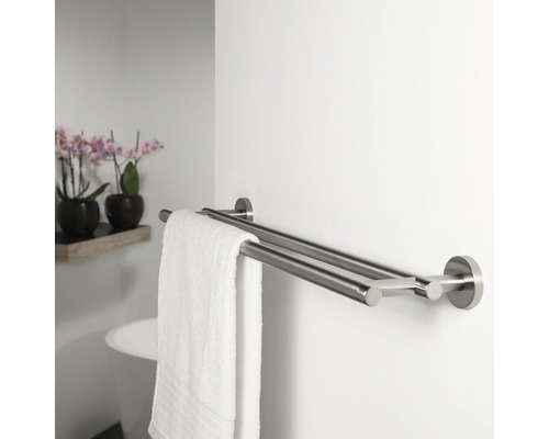 Dubbele metalen handdoekhouder met handdoek in de badkamer.