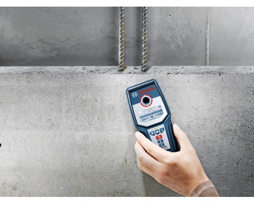 Hand houdt Bosch Logo detector voor betonnen muur met wapening