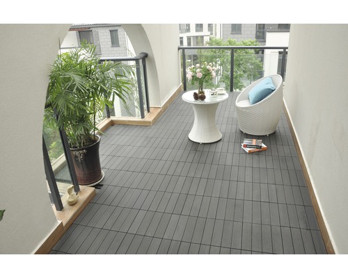 Balkon met donkere terrastegels, zithoek en plant