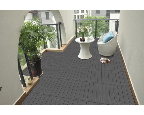 Balkon met grijze terrastegels, plant, tafel en stoel
