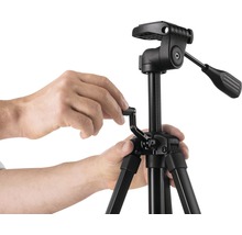 Bediening van een zwart camerastatief met statiefkop door handen