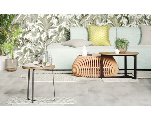 Woonkamer met bank, salontafels en planten voor een gedessineerd behang