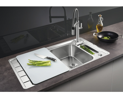 Roestvrijstalen gootsteen met snijplank en kraan op een werkblad