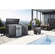 Tuinscene met tuinhuis, barbecue en familie aan de eettafel op het terras