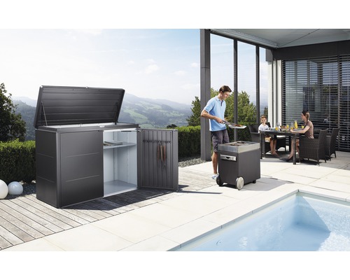 Tuinscene met tuinhuis, barbecue en familie aan de eettafel op het terras