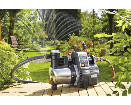 Gardena hydrofoorpomp in de tuin met gazonsproeier op de achtergrond