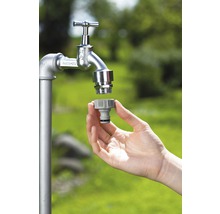 Tuinslangkoppeling wordt op een waterkraan gemonteerd