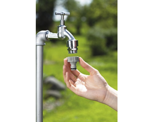 Tuinslangkoppeling wordt op een waterkraan gemonteerd