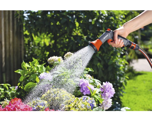 Tuinbesproeiing met een handsproeier aan een tuinslang