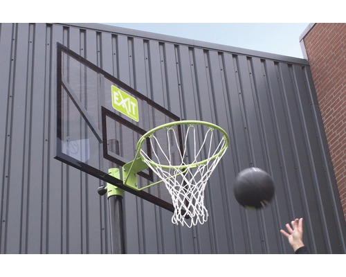 Basketbalbord met bal en net voor een muur