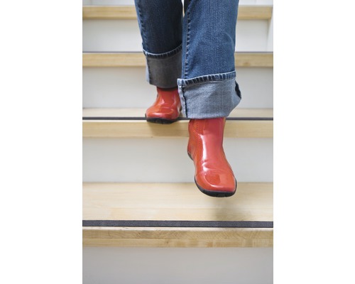 Persoon in laarzen loopt trap af met antislipstrip
