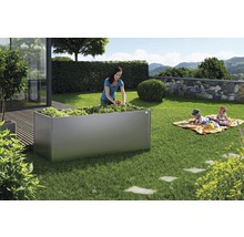 Grote plantenbak in de tuin met vrouw en kinderen op een kleed