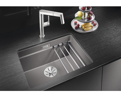 Keukenspoelbak met afdruiprek en kraan op donker aanrechtblad