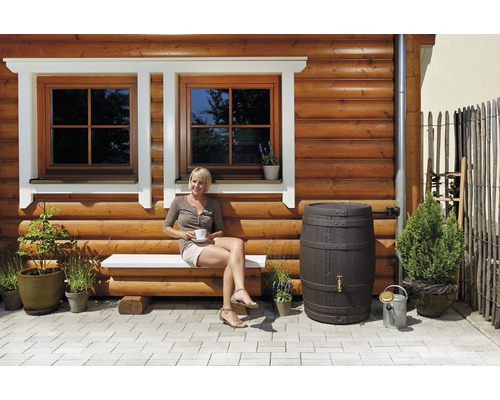 Buitenkant met houten wand, ramen, bank, zittende vrouw, regenton en planten