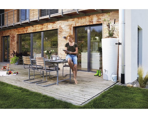 Buitenscène met tuinmeubelen, een watertank en een vrouw die een tablet gebruikt